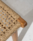 Close-up of a woven dining chair with teak frame